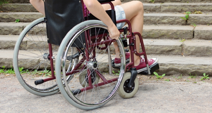 Ein Rollstuhl mit einer Person vor einer Treppe