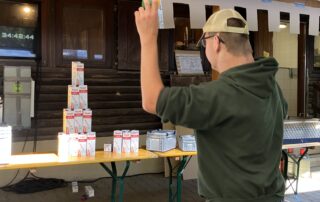 Ein Junge wirft beim "Inklusiven Zeltlager" mit einem Ball eine Tetrapack-Pyramide um.